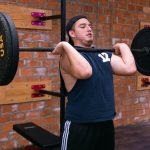 A man focuses on lifting a heavy barbell in a Ciudad de México gym.